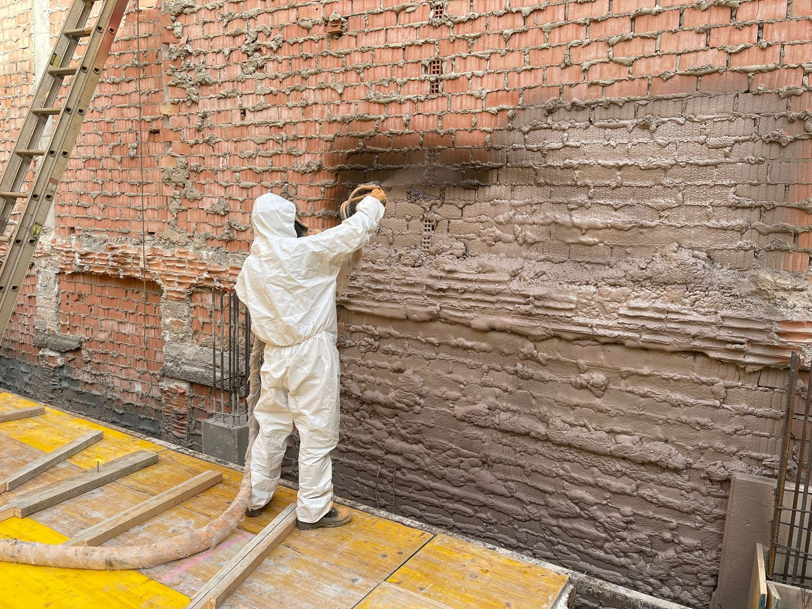 Aplicación de espuma de poliuretano proyectada sobre una pared